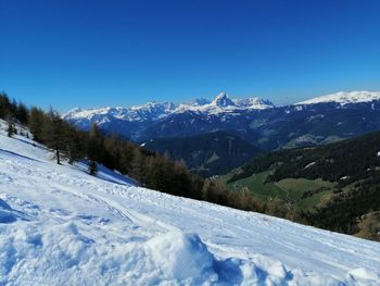 Scenic view of snowcapped mountains against clear blue sky