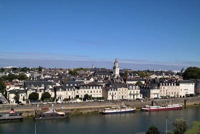 River amidst buildings in city against sky