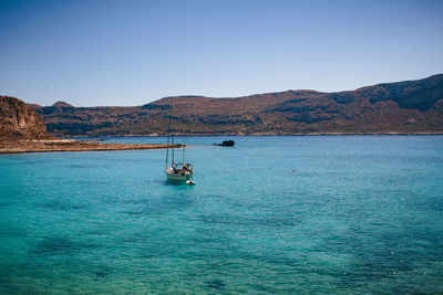Boat sailing in sea against clear sky