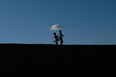 Men running on field against sky