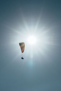 Low angle view of person paragliding against the sky