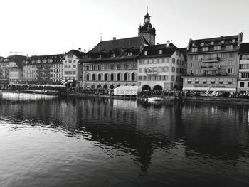 Reflection of buildings in river against clear sky