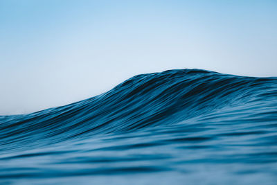 Low angle view of sea against clear blue sky