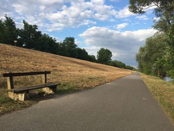 Road by trees against sky