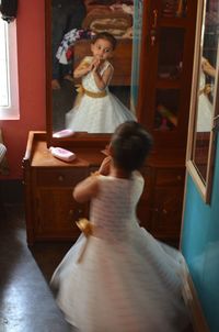 Rear view of girl standing at home