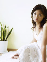 Woman sitting on fur rug at home