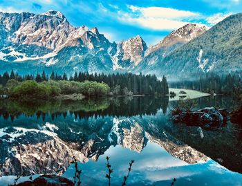 Scenic view of lake and snowcapped mountains against sky