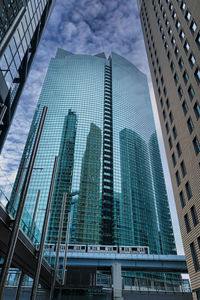 Low angle view of modern glass building against sky