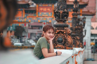 Portrait of a smiling young woman sitting outdoors