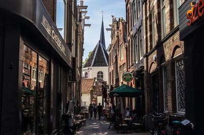 People at alley amidst buildings in city