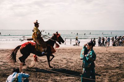 People riding horse on beach