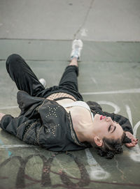 Full length of young woman lying on street
