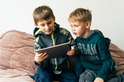 Boys looking away while sitting on camera