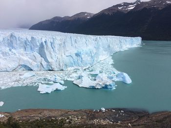 Scenic view of frozen sea against mountain