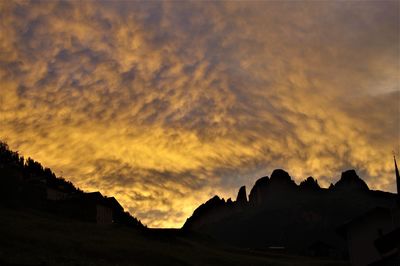 Low angle view of silhouette mountain against dramatic sky