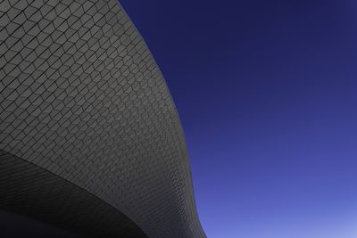 Low angle view of modern building against clear blue sky