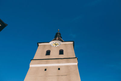 Low angle view of bell tower against blue sky