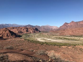 Scenic view of landscape and mountains against clear blue sky