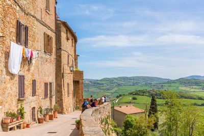 People on road amidst buildings against sky