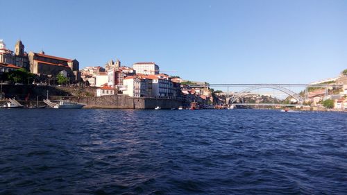 Sea by city against clear blue sky