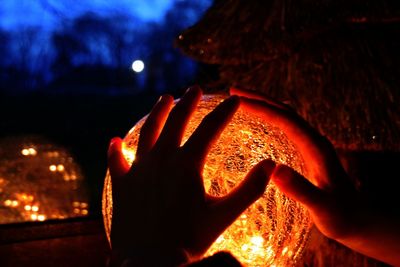 Close-up of hand holding lit up at night