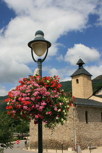 Low angle view of street light by building against sky