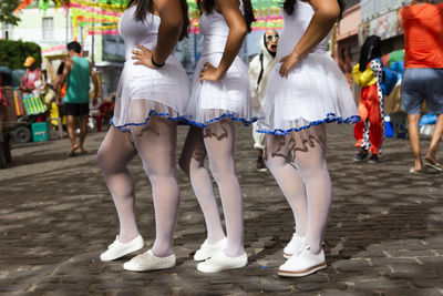 Low section of people walking on street with carnival costume