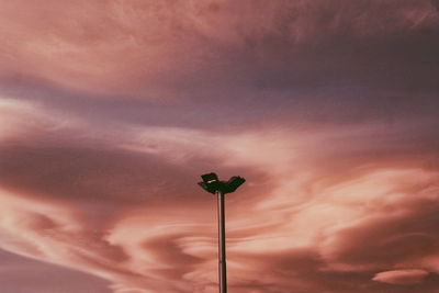 Low angle view of street light against dramatic sky