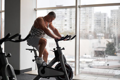 Full length of man exercising at gym