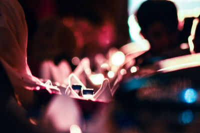 Close-up of hand on illuminated lighting equipment