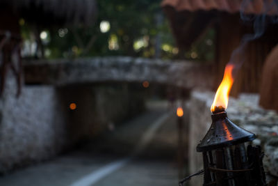 Close-up of burning candles on metal