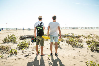 Rear view of man standing at beach