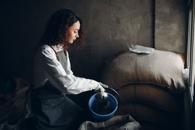 Side view of young woman sitting at home