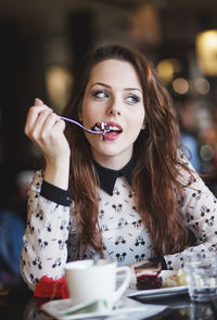 Portrait of young woman eating cake