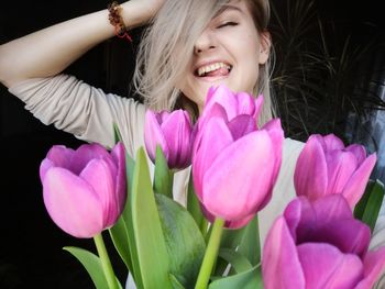 Close-up portrait of smiling woman with pink flower