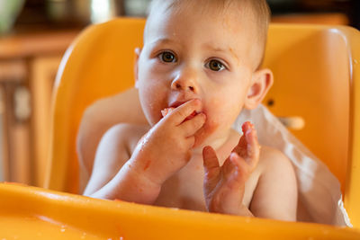 Portrait of cute baby girl eating fruit