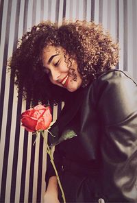Close-up of young woman with red rose
