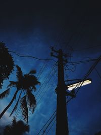 Low angle view of silhouette electricity pylon against sky