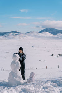 Rear view of man standing on snow covered landscape