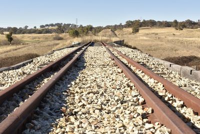 Railroad track amidst field against sky