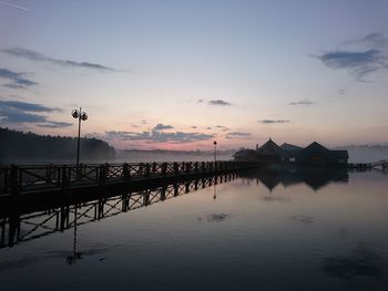 Silhouette pier on lake against sky during sunset