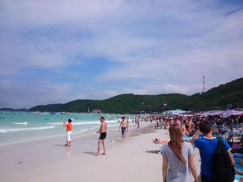 People enjoying at beach against sky