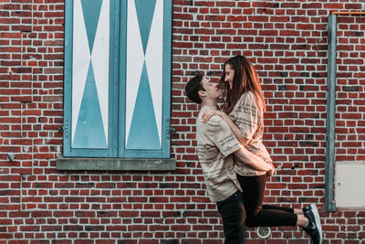 Woman standing against brick wall