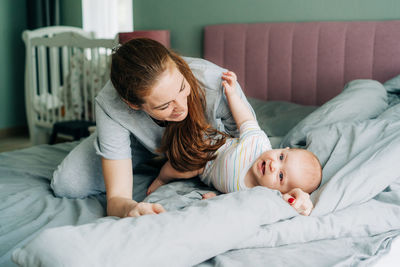 Happy mom and baby have time together in bed. happy family home life. 