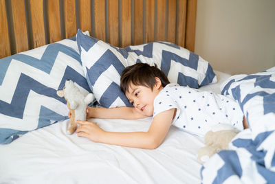 Cute boy sleeping on bed playing with toy