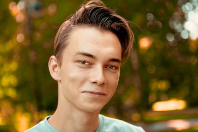 Close-up portrait of smiling young man outdoors