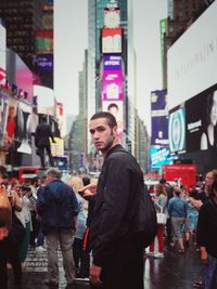 Portrait of young man standing on street at times square