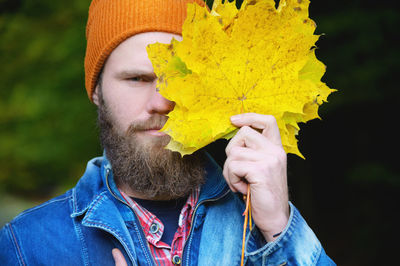 Portrait of young man holding yellow hat