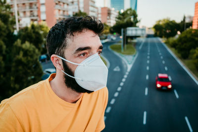 Close-up of man wearing mask looking away in city