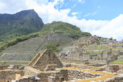 Old ruins on mountain against cloudy sky